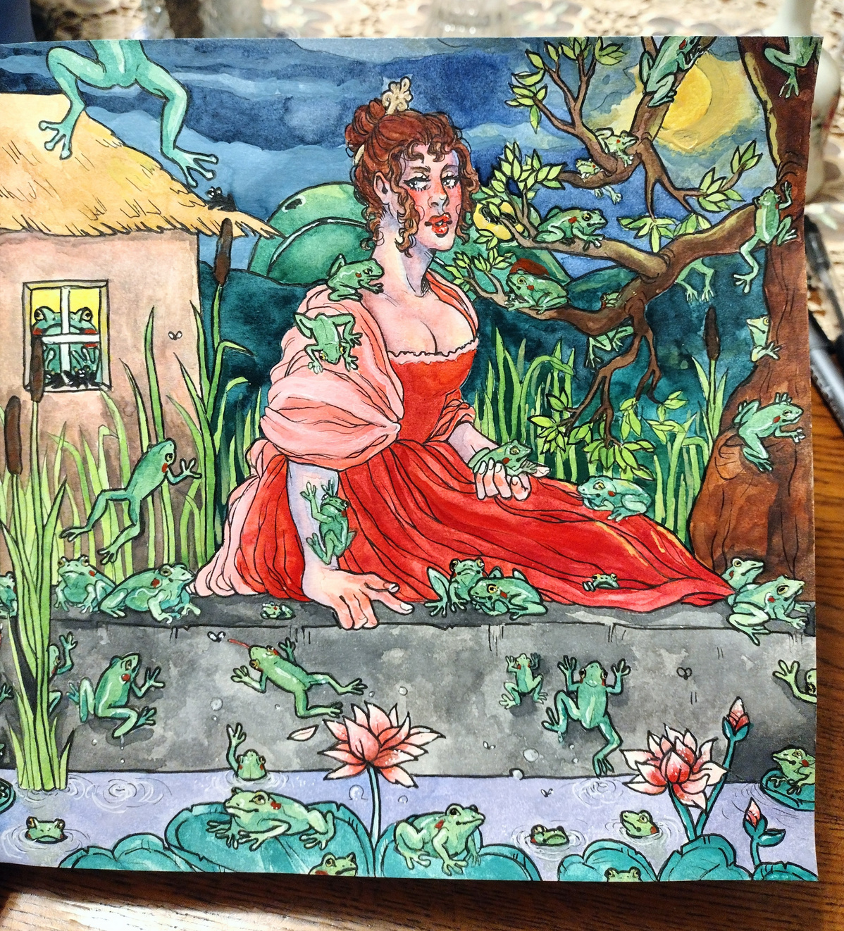 A woman in a flowing red dress sits at a pond. She is surrounded by cattails and reeds. The background and foreground are dotted with frogs of various shapes and sizes. 